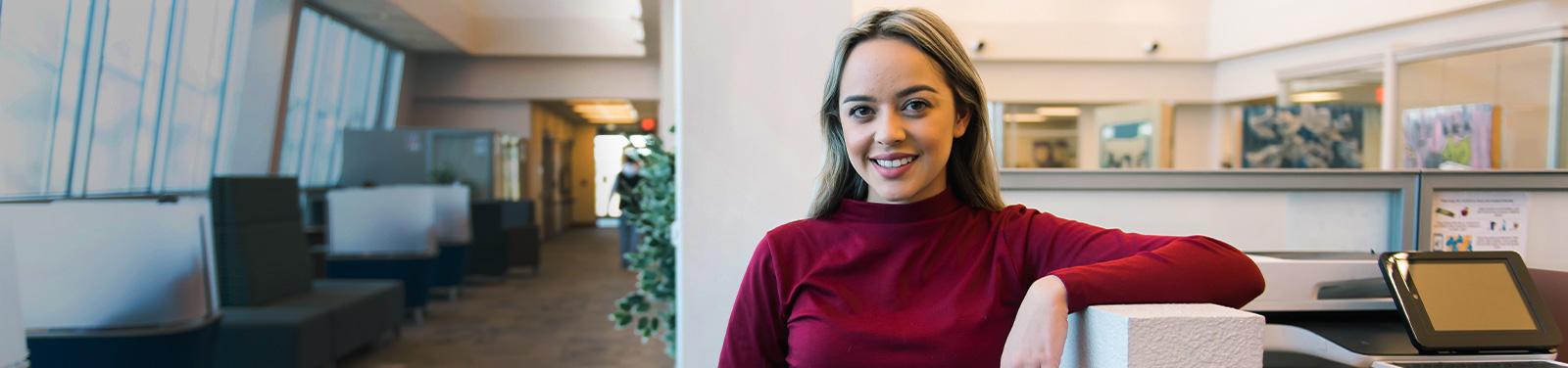 A student stands in a student lounge at a Pima Campus